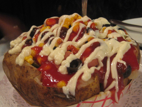 Khumpir (stuffed baked potato) with olives, corn, beef sausage, pickle; $12